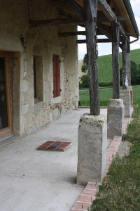 Pose d'une frise et d'un carré central en carreaux anciens de terre cuite pour une future terrasse bois